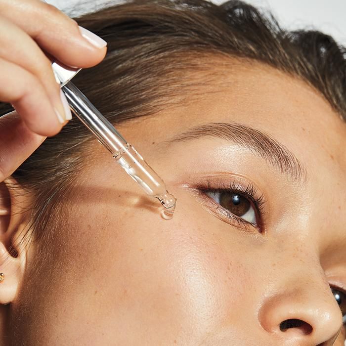 Applying retinol serum to face for smoother, youthful skin.