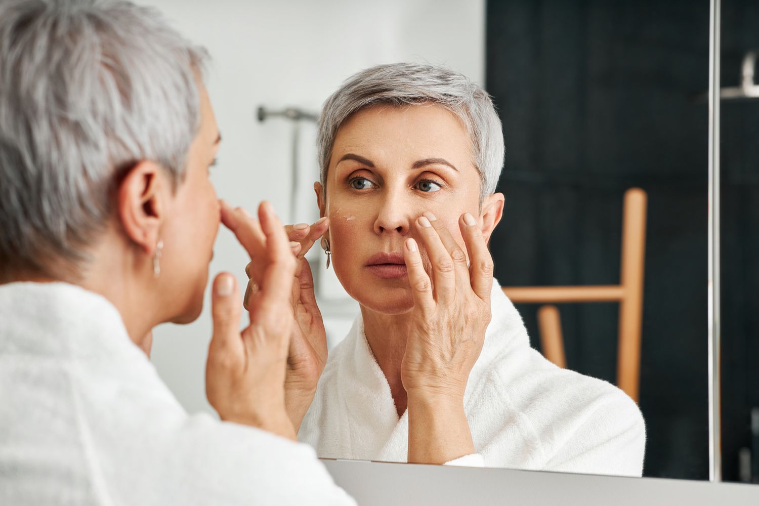 A woman applying retinol serum during her night time skincare routine