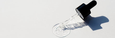 Picture of a serum dropper lying open on a grey background from Pals Skin Lab